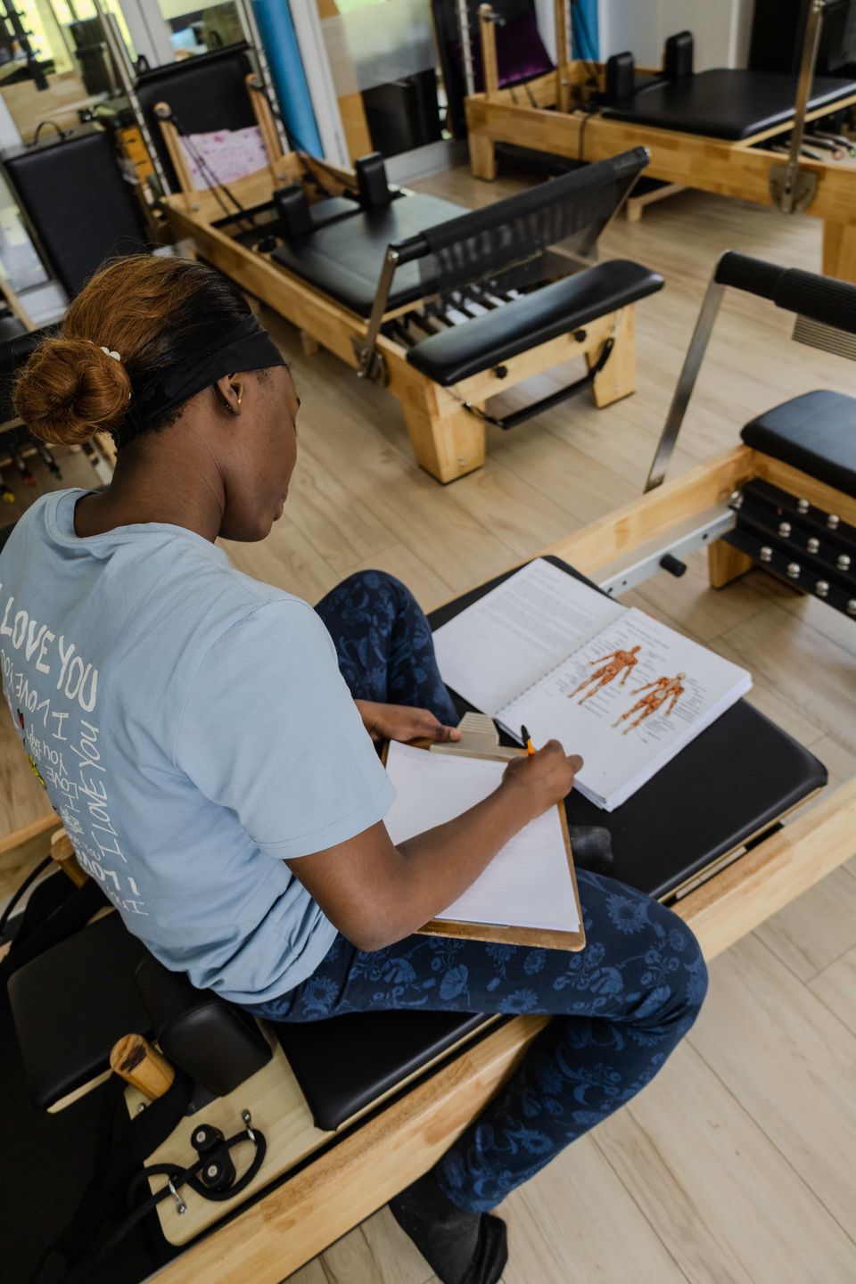A trainee instructor making anatomy notes on a reformer during a Pilates teacher training course in Johannesburg