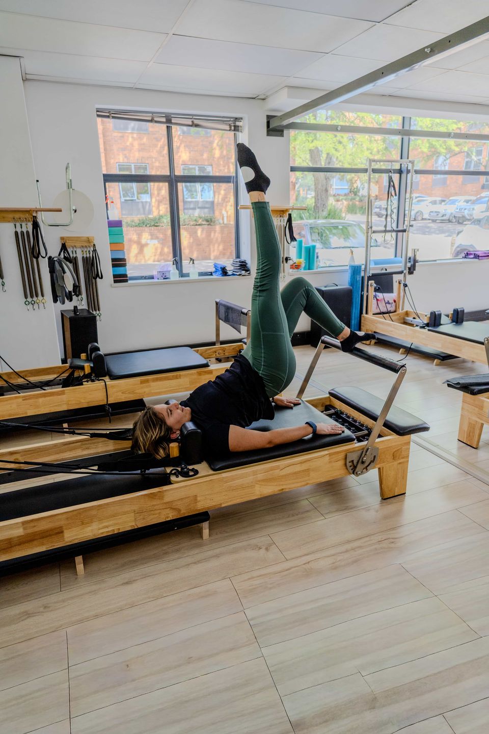 Instructor Myrren doing single-leg work on a reformer in the Pilates Dynamics studio in Randburg